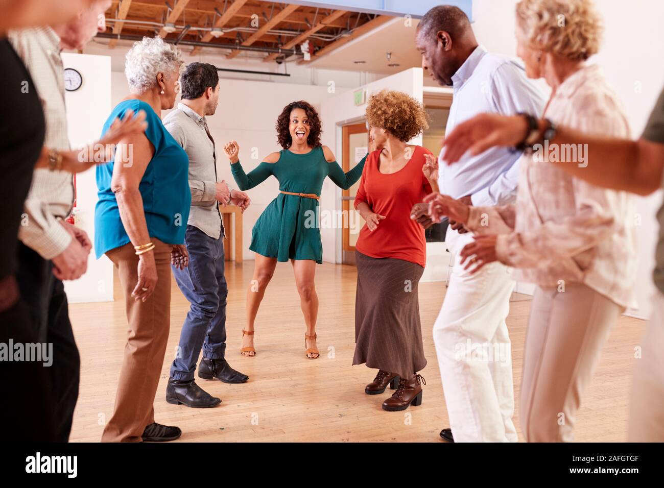 People Attending Dance Class In Community Center Stock Photo