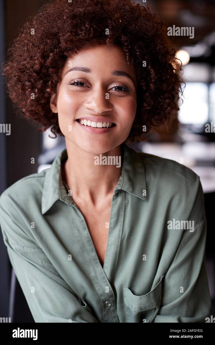 Close up portrait of millennial black female creative in an office smiling to camera Stock Photo