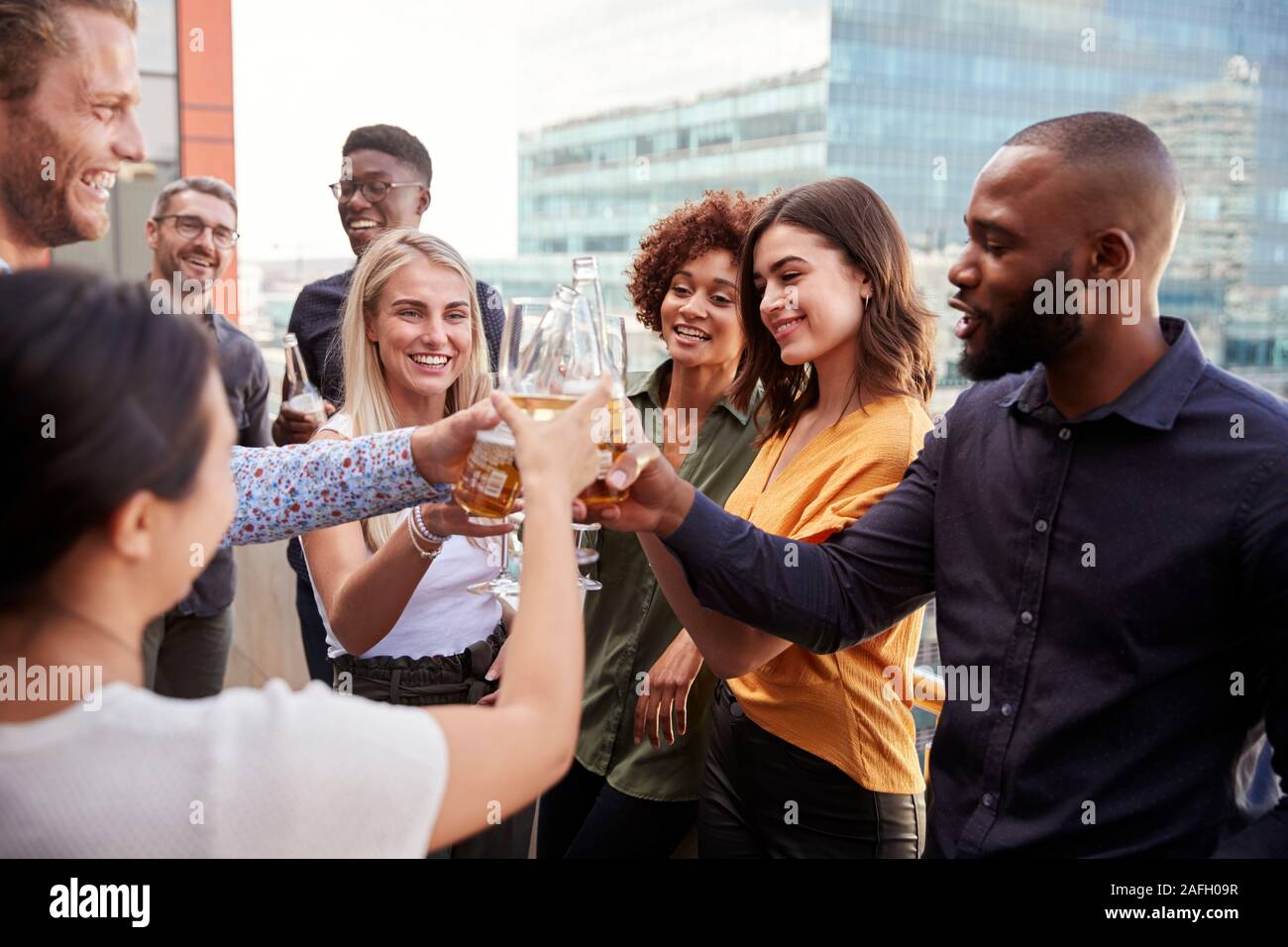 Creative business colleagues raising glasses and making a toast with drinks after work Stock Photo