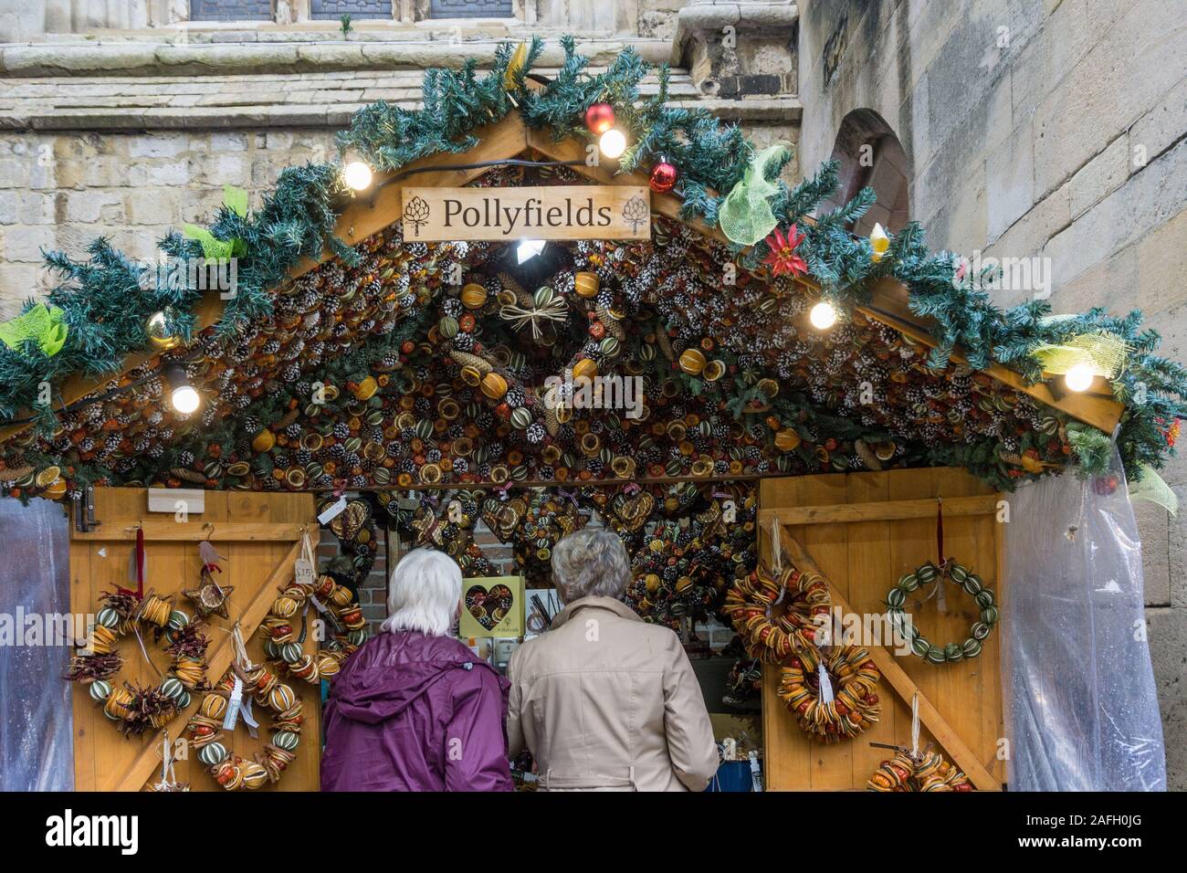 Visitors to Winchester Christmas Market next to the Cathedral, Winchester, Hampshire, UK Stock Photo