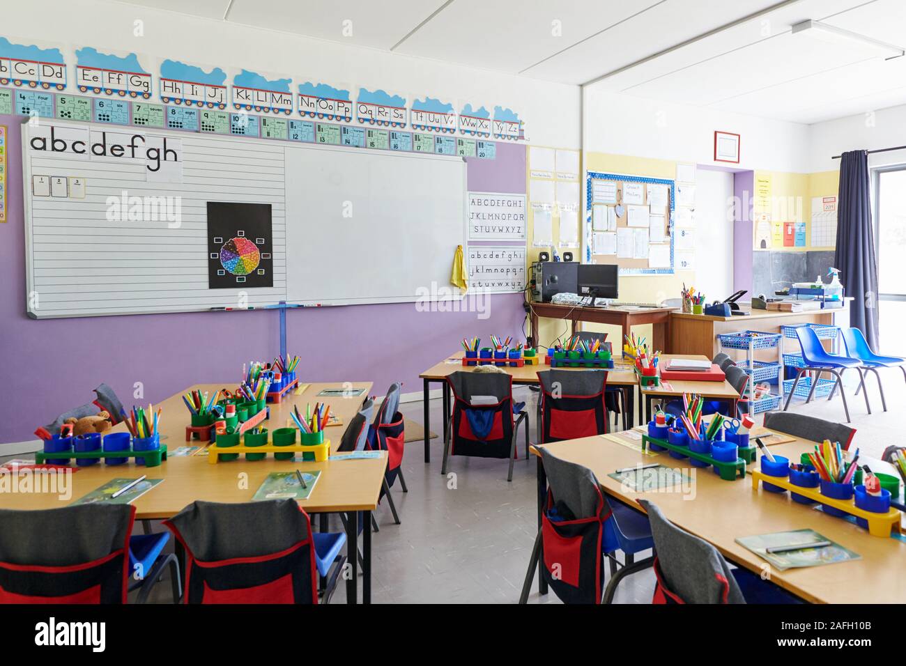 Empty Classroom In Elementary School With Whiteboard And Desks Stock Photo