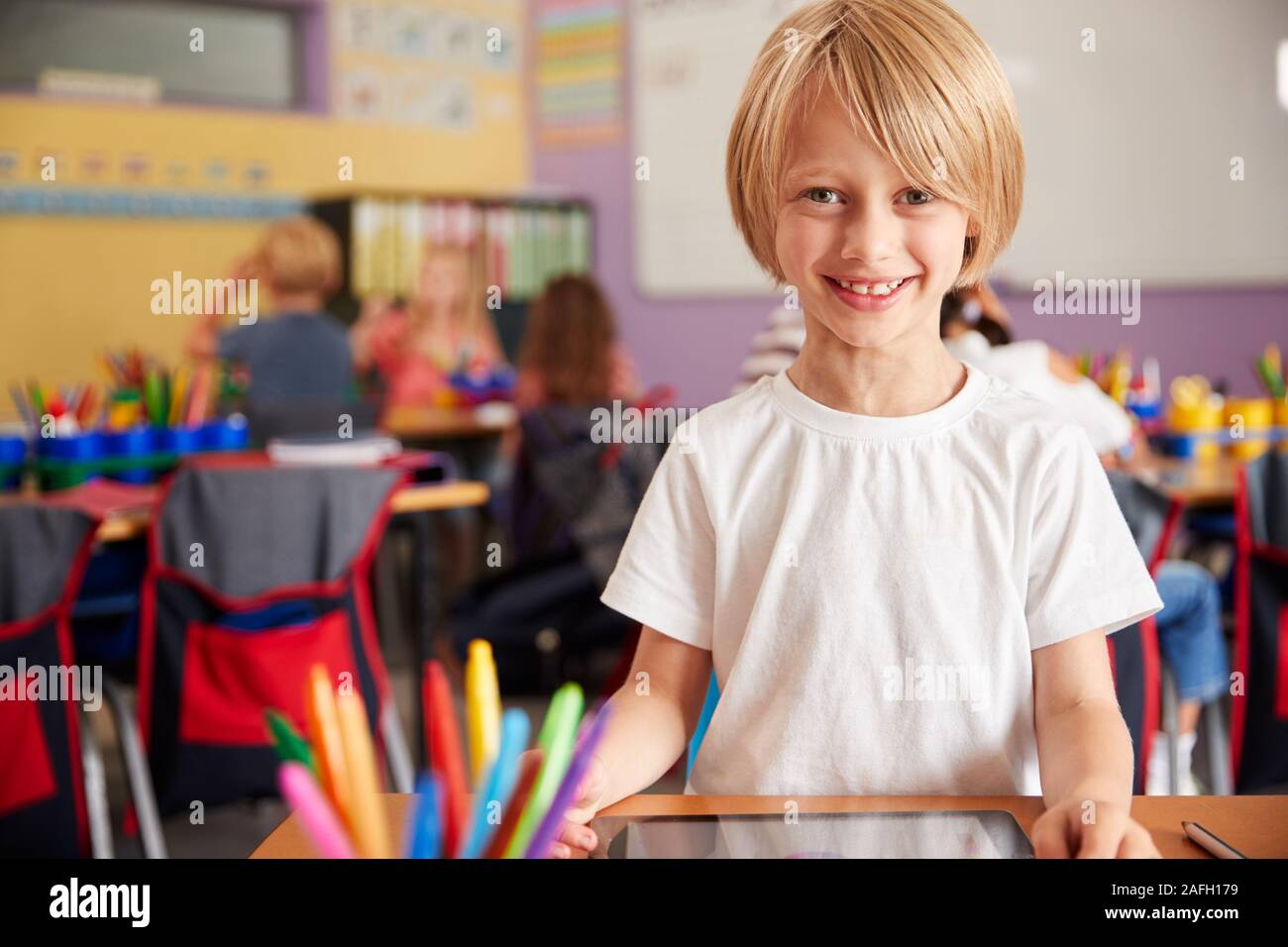 Portrait Of Male Pupil In Elementary School Drawing Using Digital ...