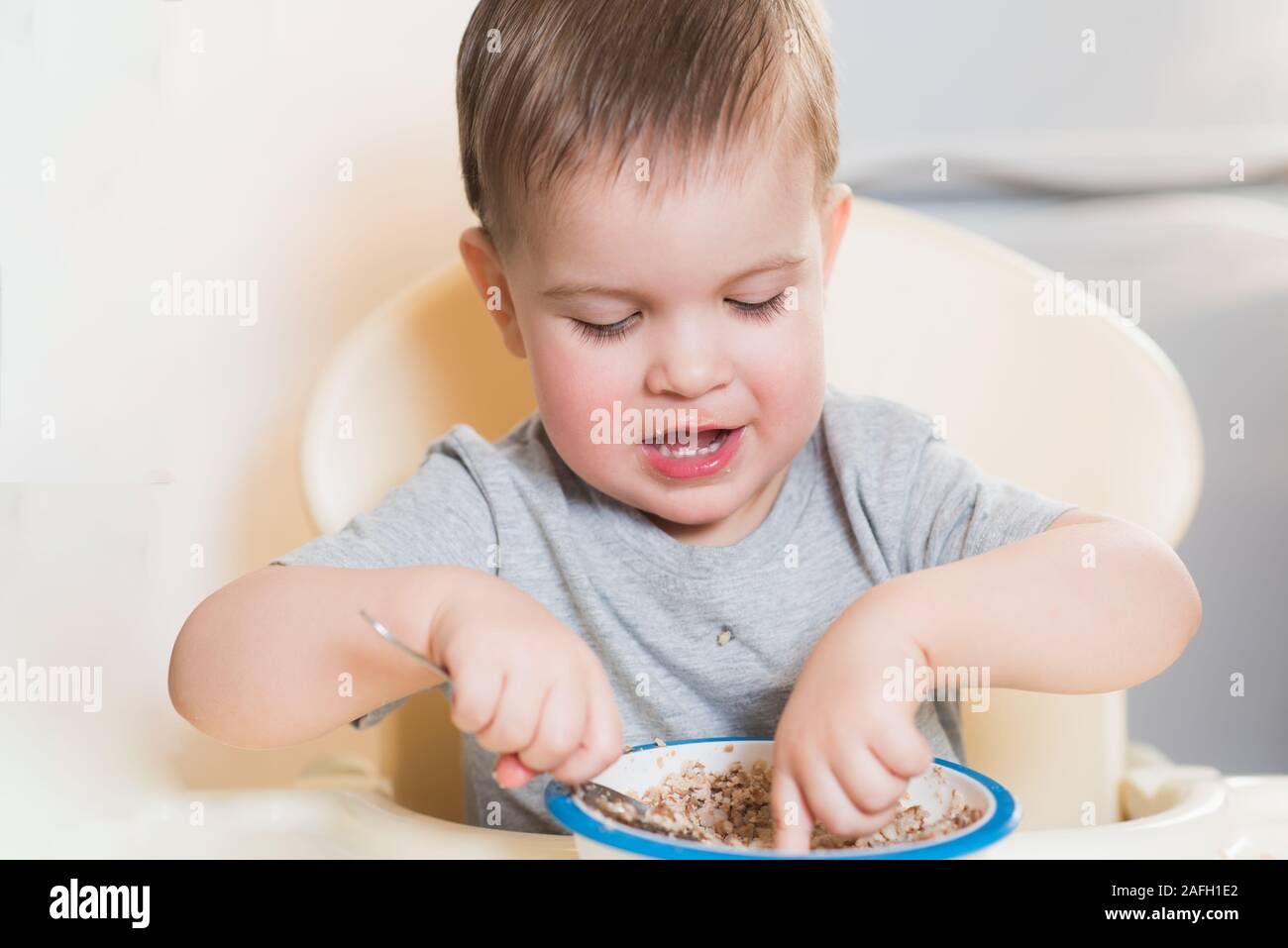 the child eats buckwheat porridge in the kitchen Stock Photo Alamy