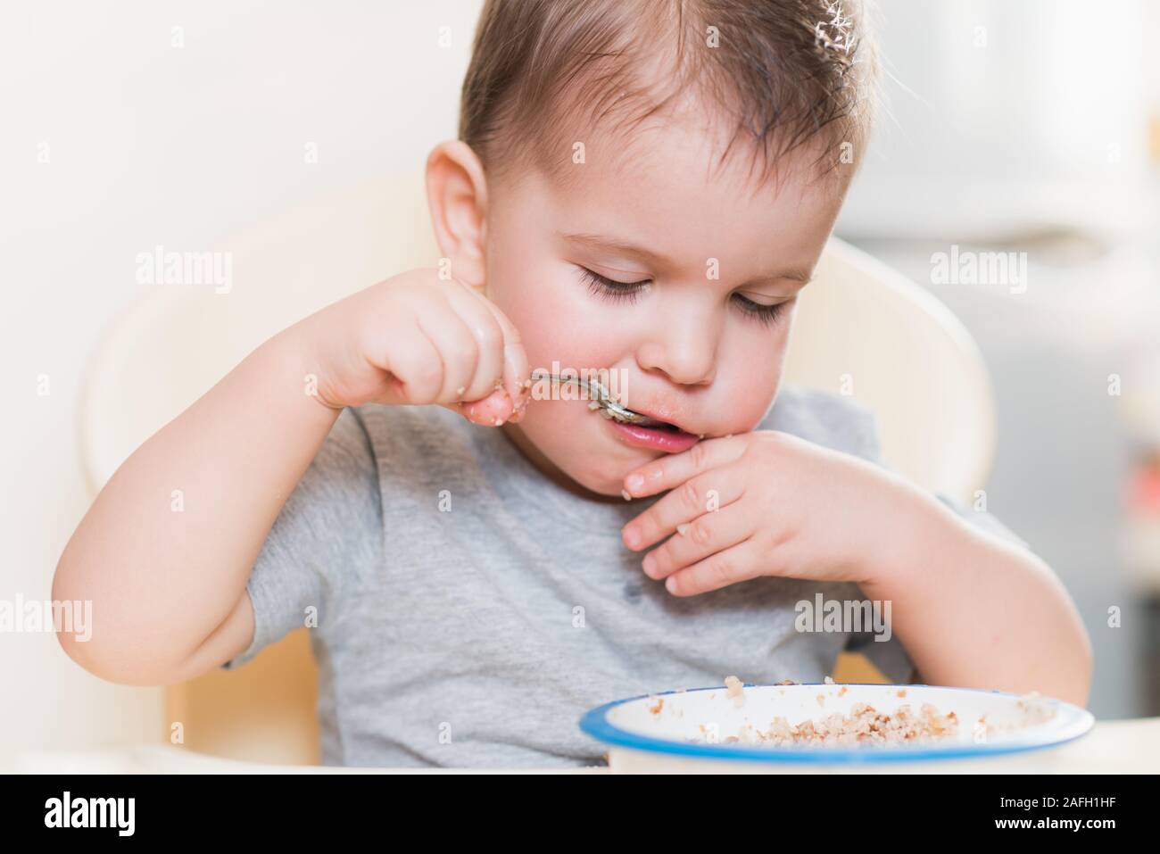 the child eats buckwheat porridge in the kitchen Stock Photo Alamy