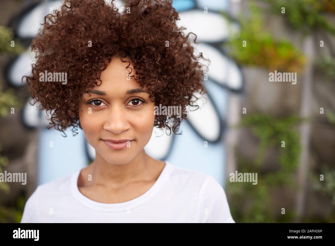 Outdoor Head And Shoulders Portrait Of Smiling Young Woman Stock Photo