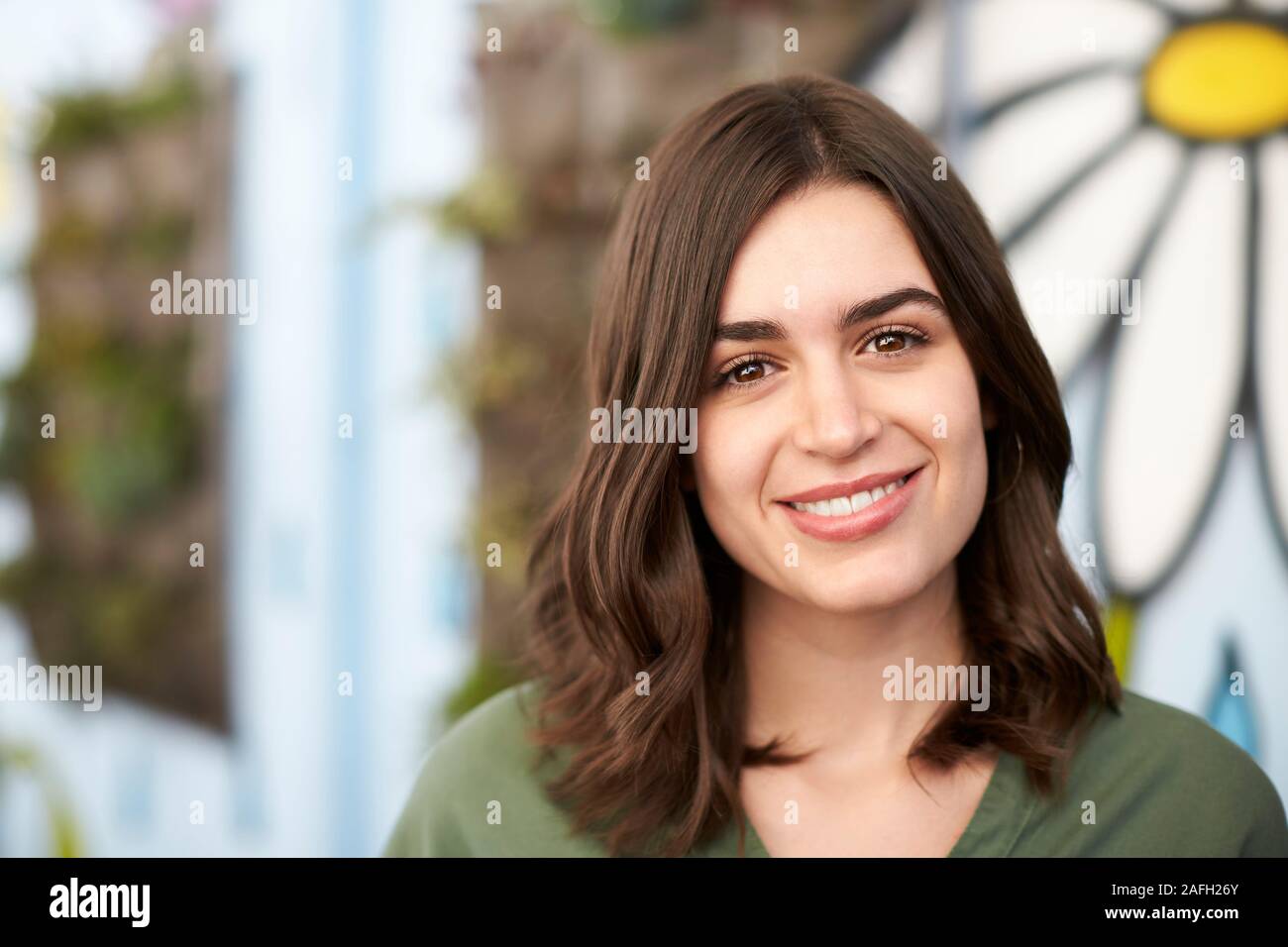 Outdoor Head And Shoulders Portrait Of Smiling Young Woman Stock Photo