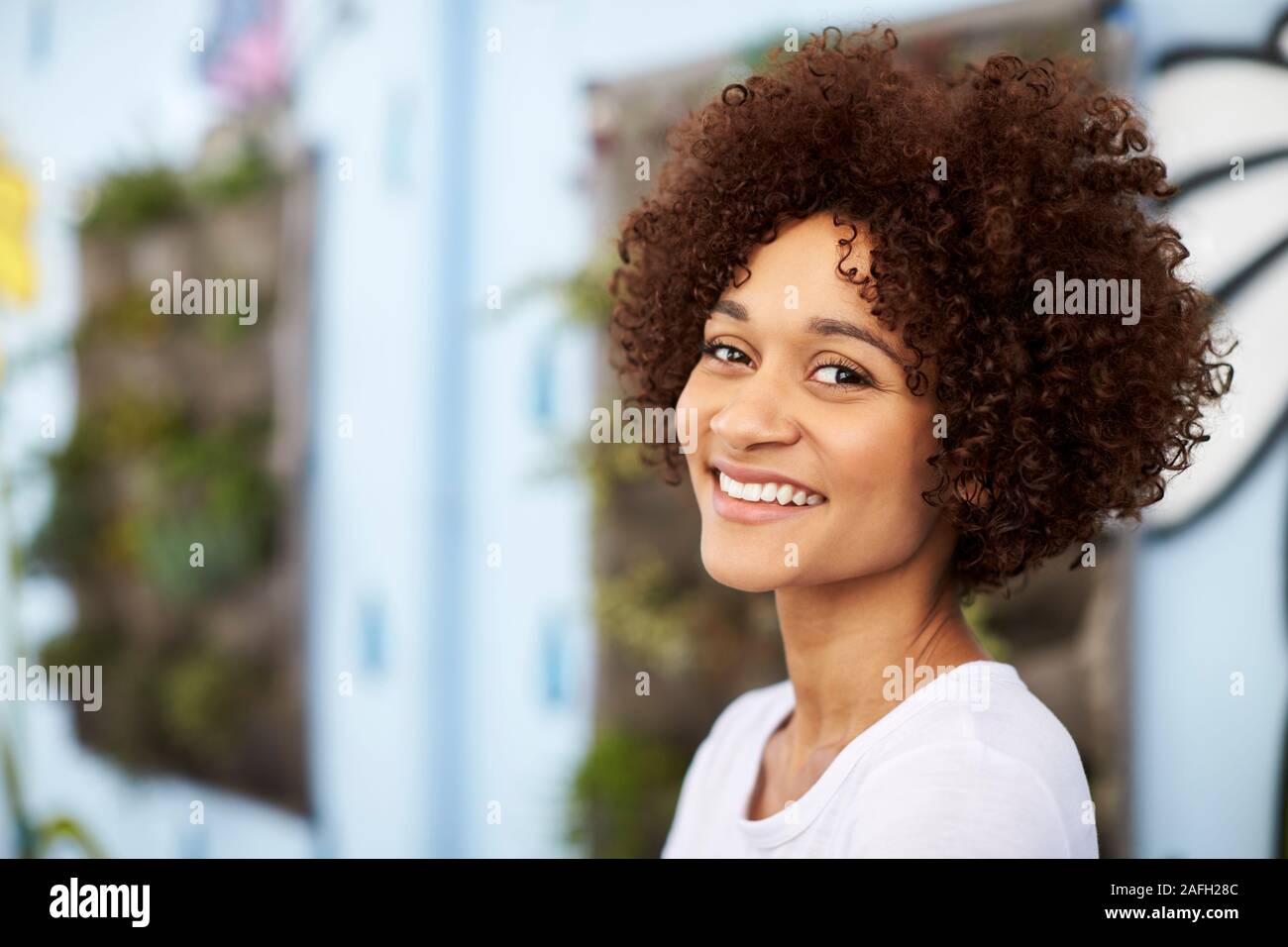 Outdoor Head And Shoulders Portrait Of Smiling Young Woman Stock Photo