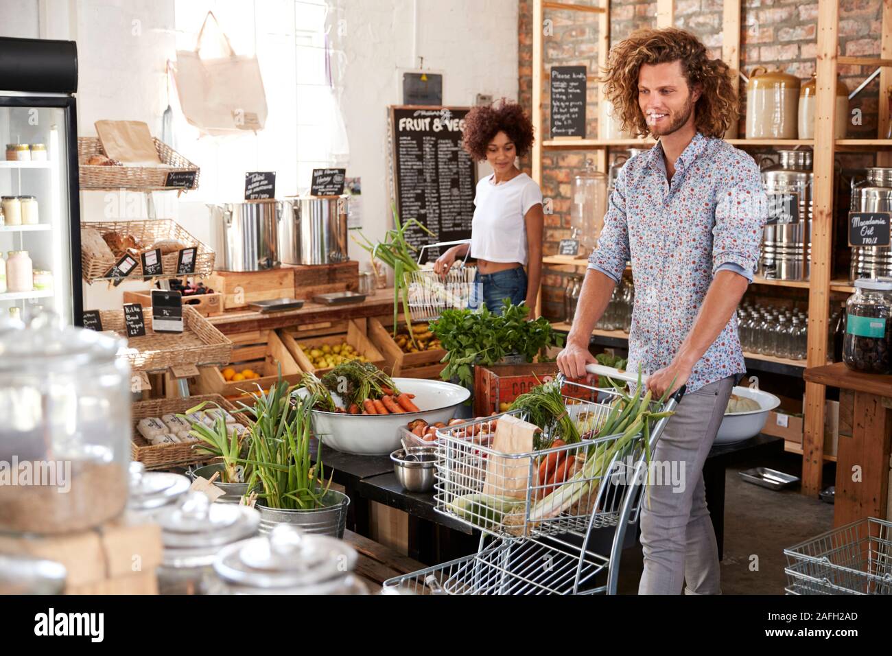 Shoppers Buying Fresh Fruit And Vegetables In Sustainable Plastic Free