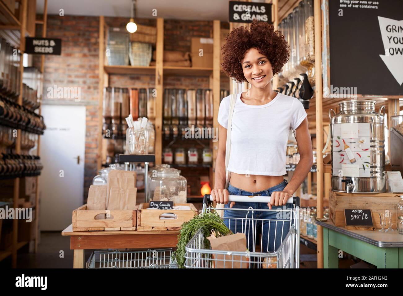 Portrait Of Woman With Shopping Trolley Buying Fresh Vegetables In