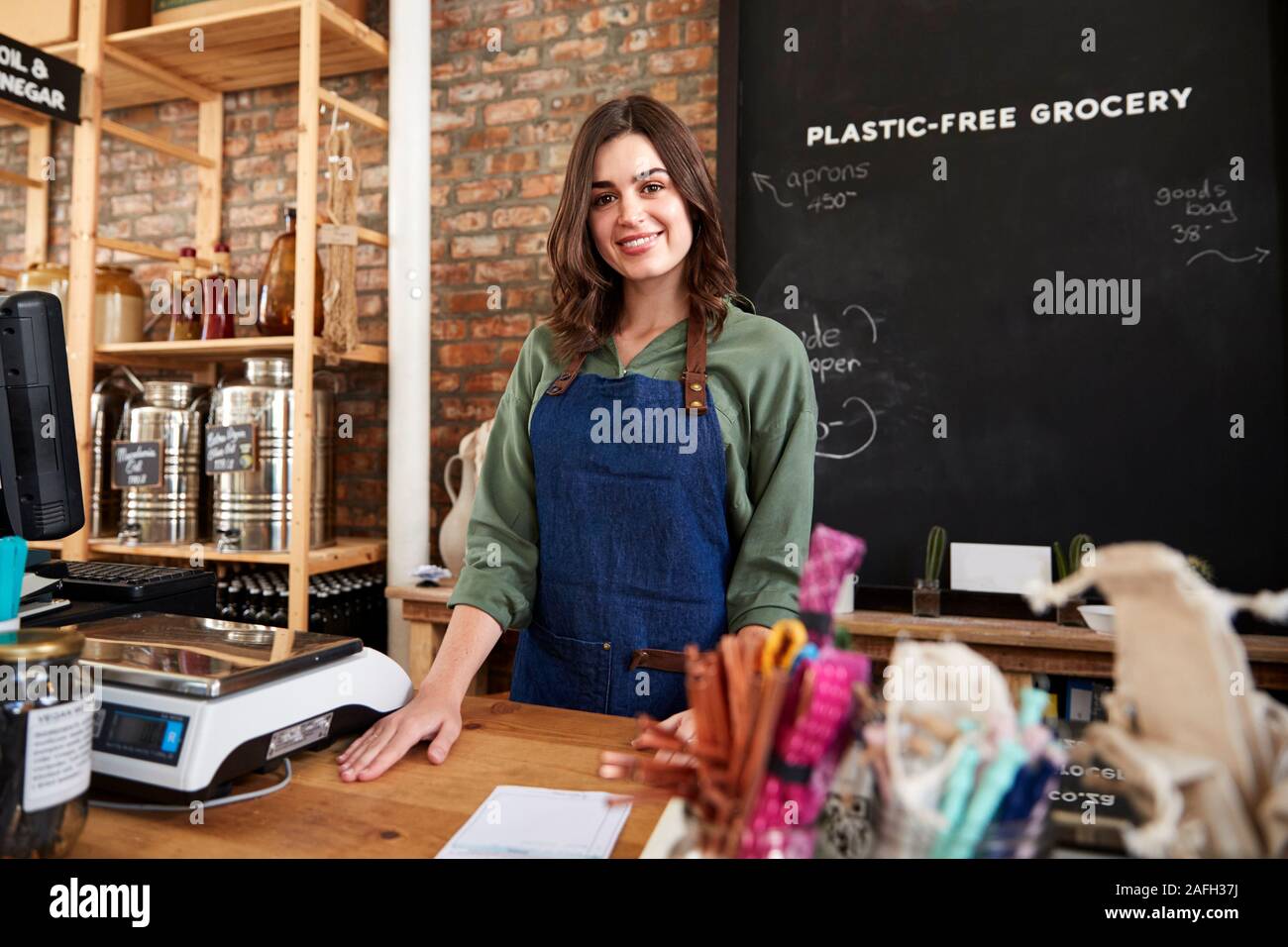 Portrait Of Female Owner Of Sustainable Plastic Free Grocery Store Behind Sales Desk Stock Photo