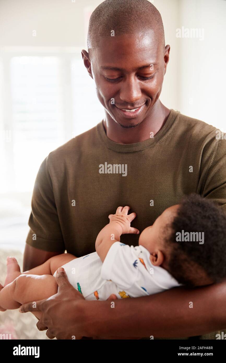 Proud Father Cuddling Baby Son In Nursery At Home Stock Photo Alamy
