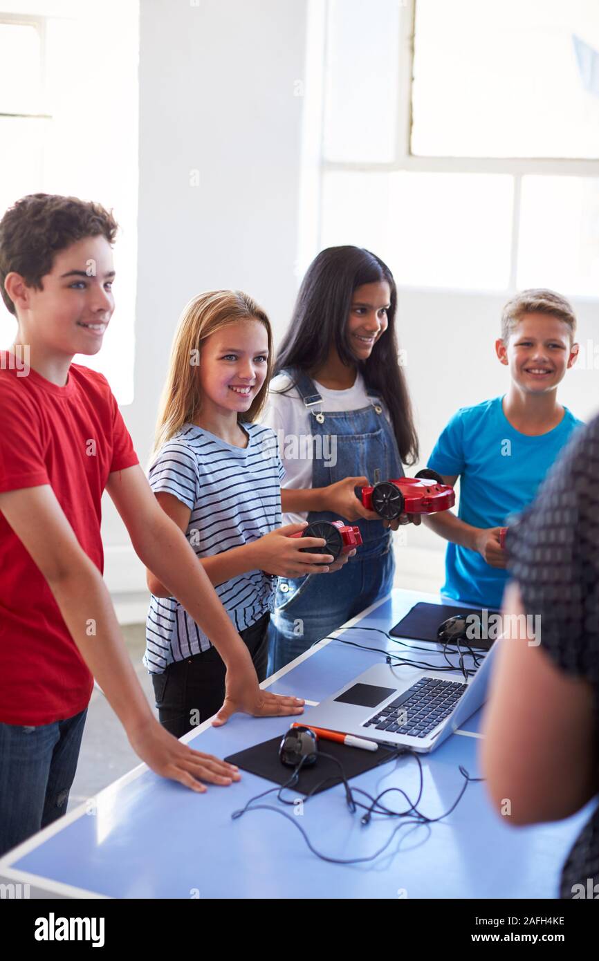 Group Of Students In After School Computer Coding Class Learning To Program Robot Vehicle Stock Photo