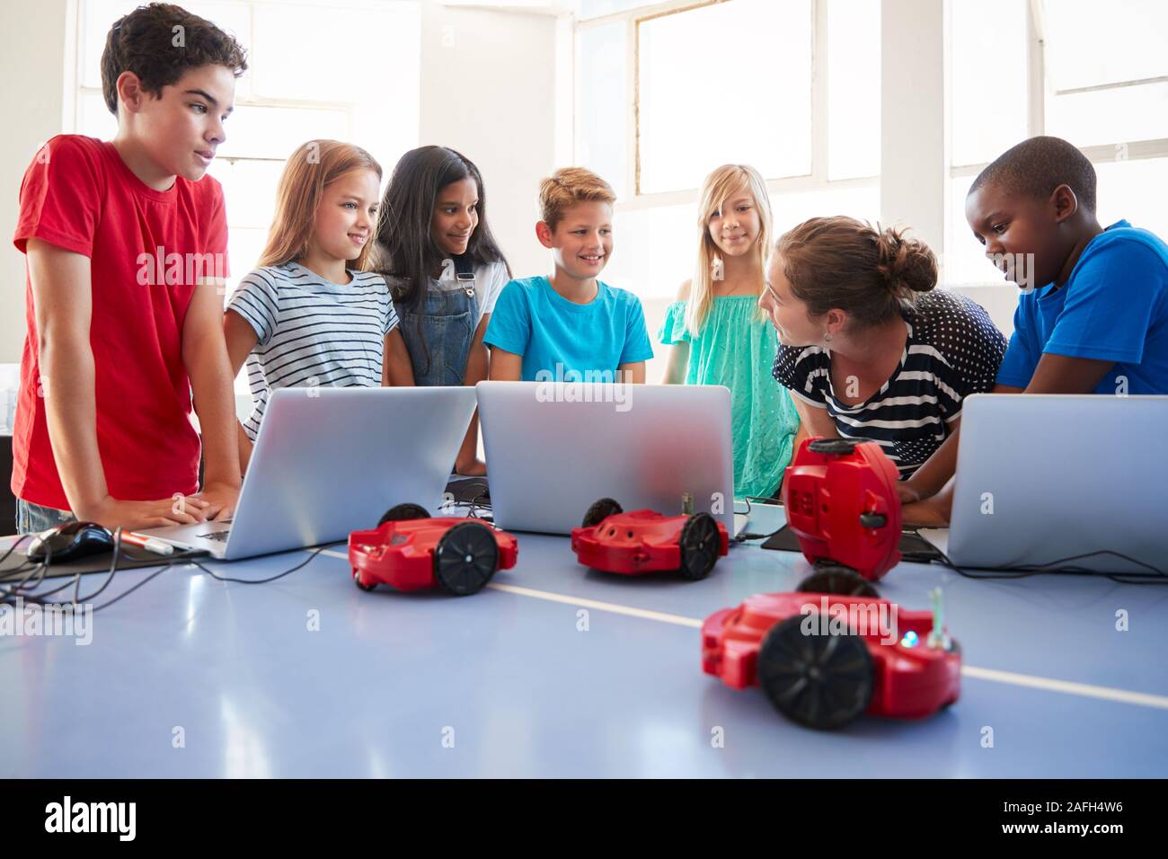 Group Of Students In After School Computer Coding Class Learning To Program Robot Vehicle Stock Photo
