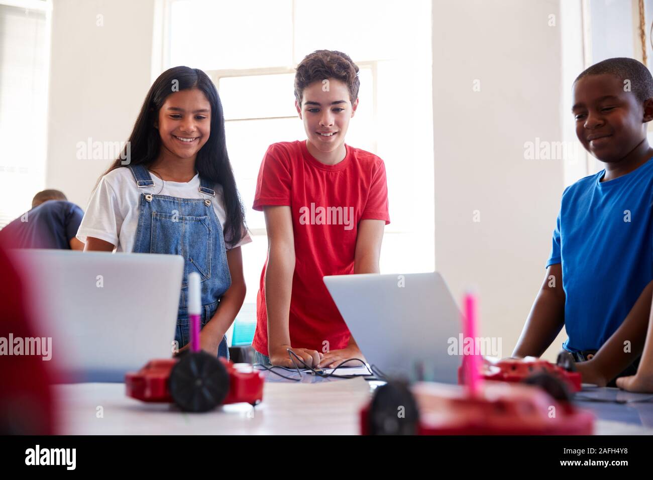Three Students In After School Computer Coding Class Learning To ...