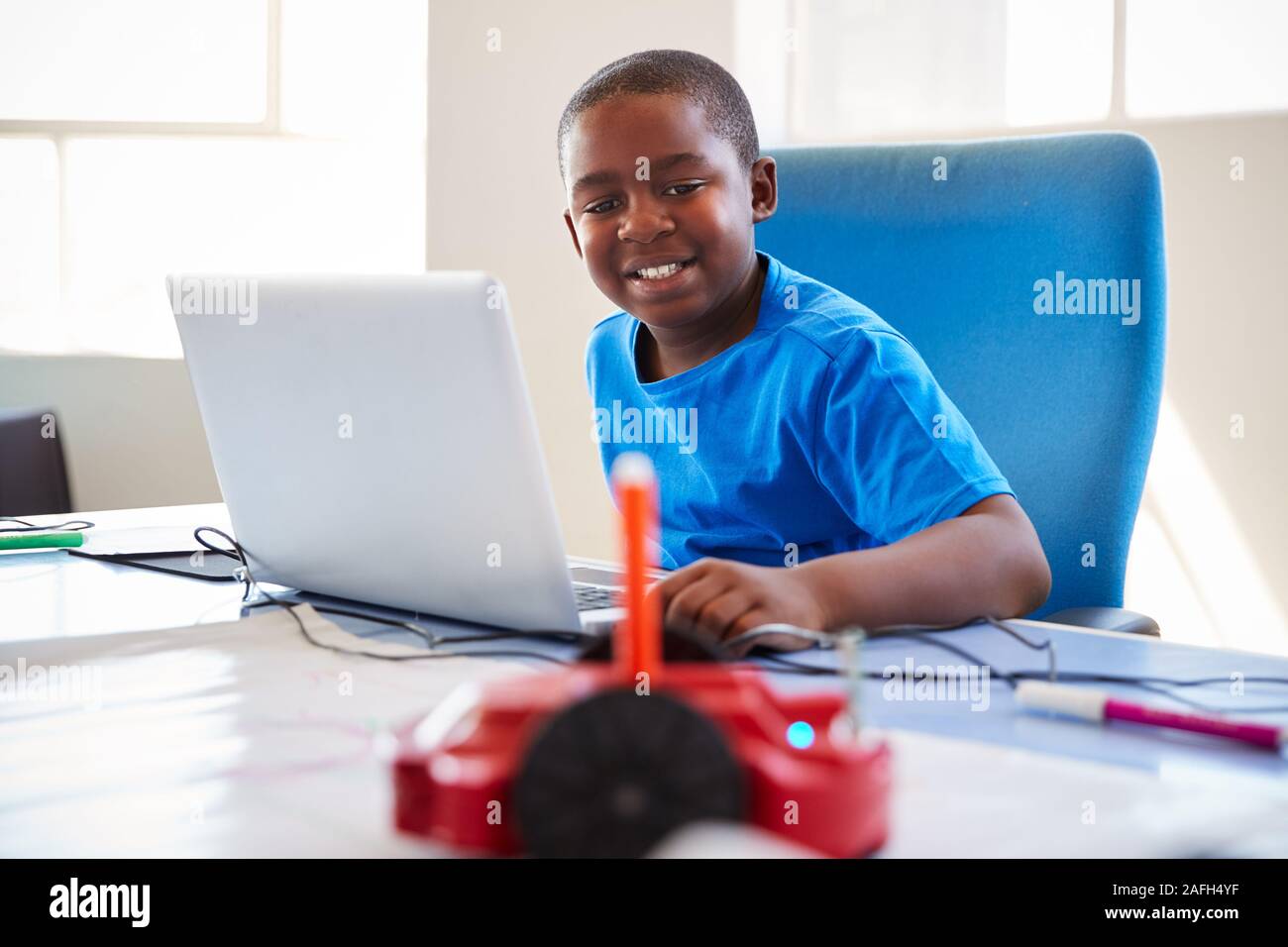 Male Student In After School Computer Coding Class Learning To Program Robot Vehicle Stock Photo