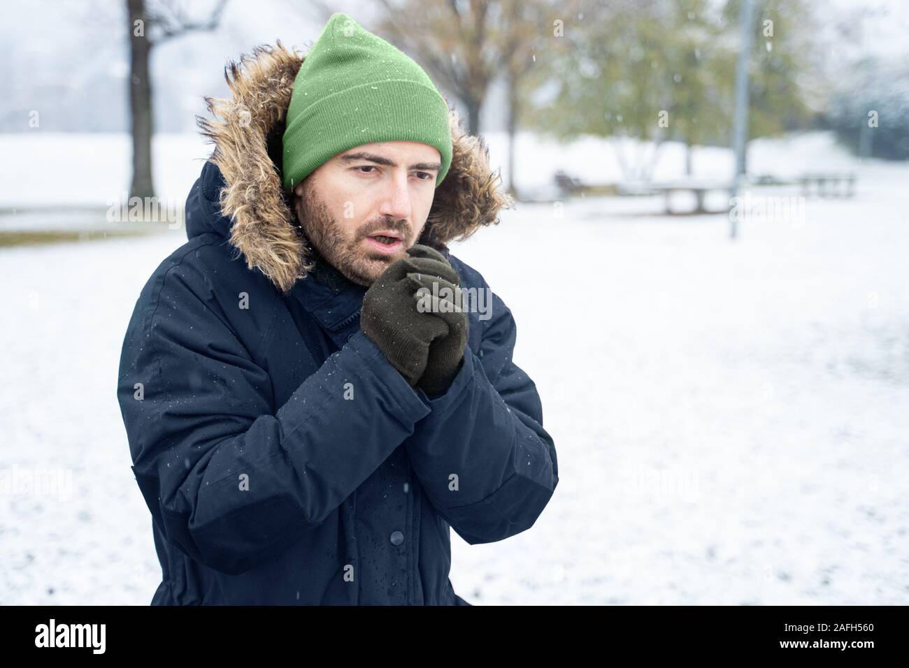 Man wearing clothes and beanie in snow Stock Photo -