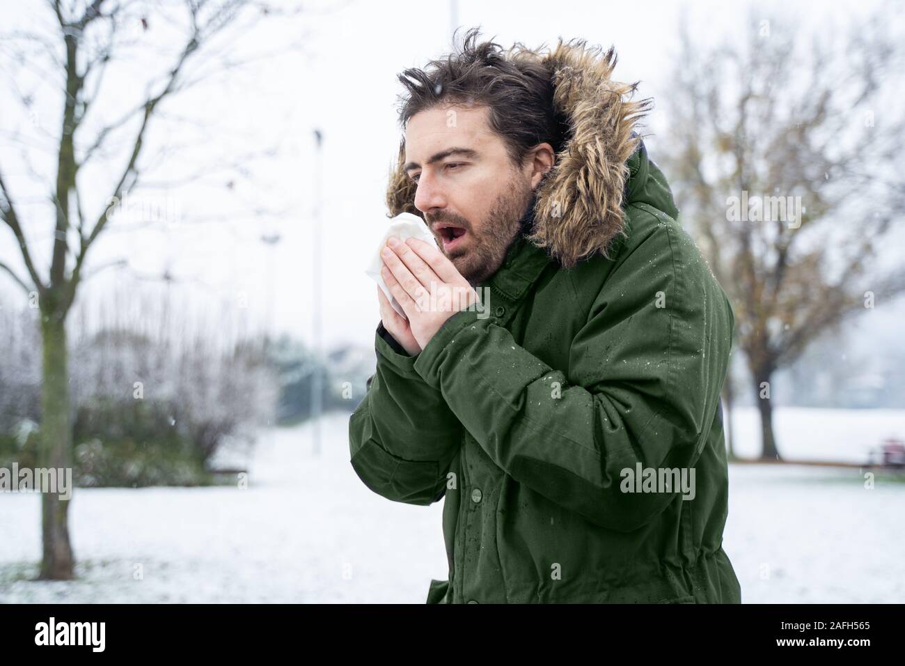 Man wearing warm clothes freezing in the snow Stock Photo