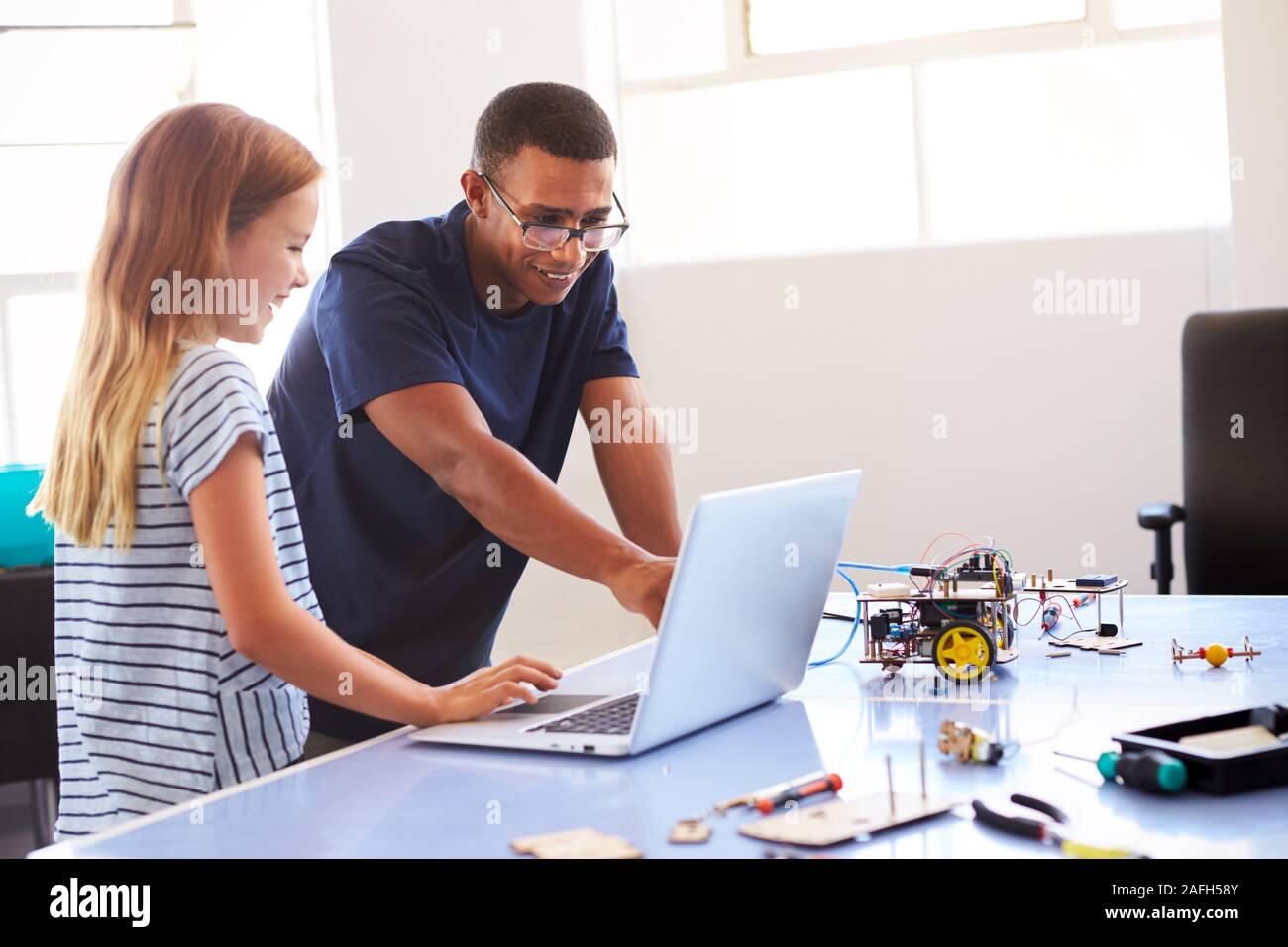 Female Student With Teacher Building Robot Vehicle In After School ...