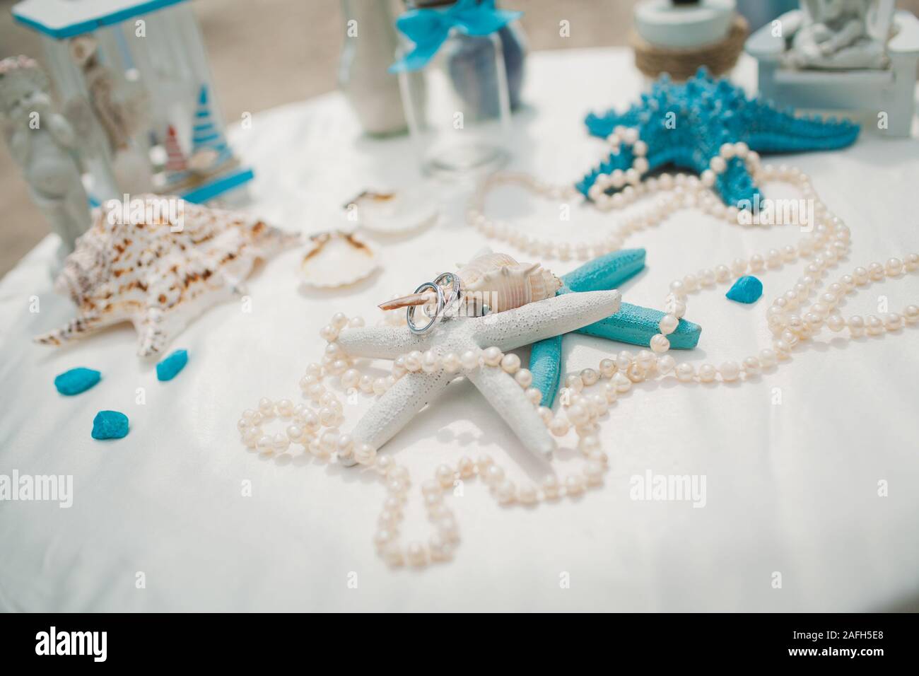 White and blue wedding decorations on a white table on a beach