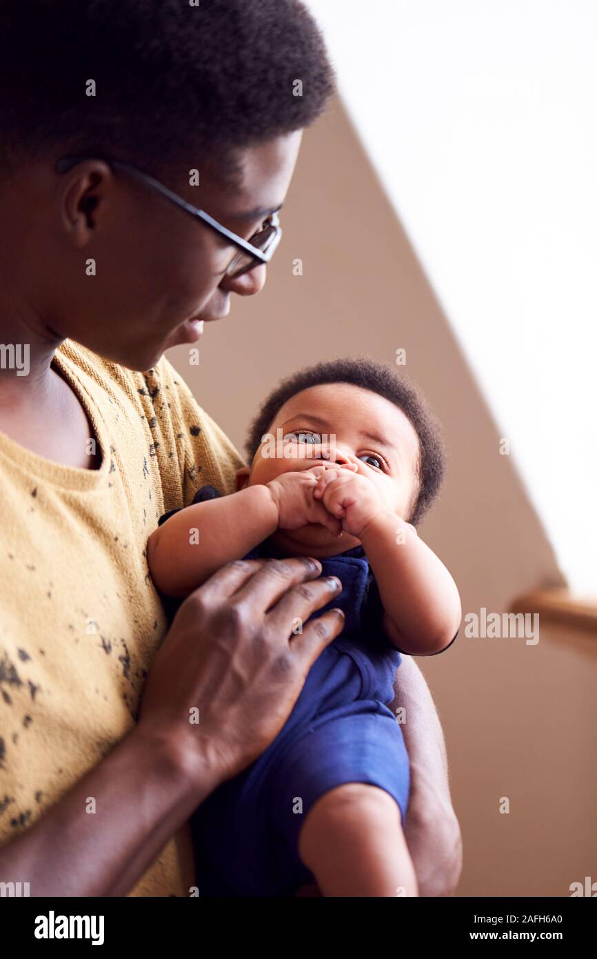 Loving Father Holding Newborn Baby At Home In Loft Apartment Stock Photo