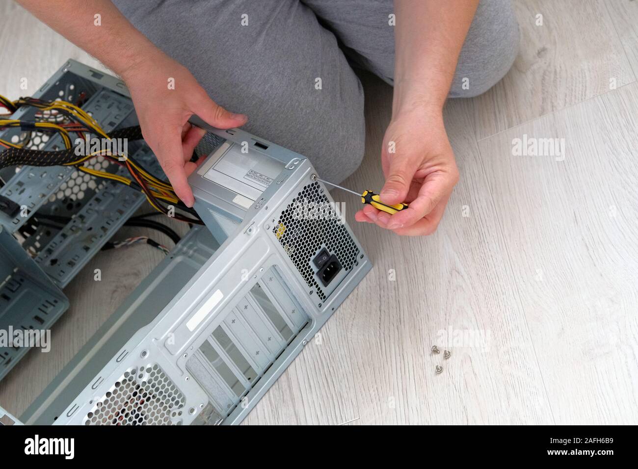 Computer engineer hold screwdriver for repairing PC. Service electronics and computers concept. Stock Photo