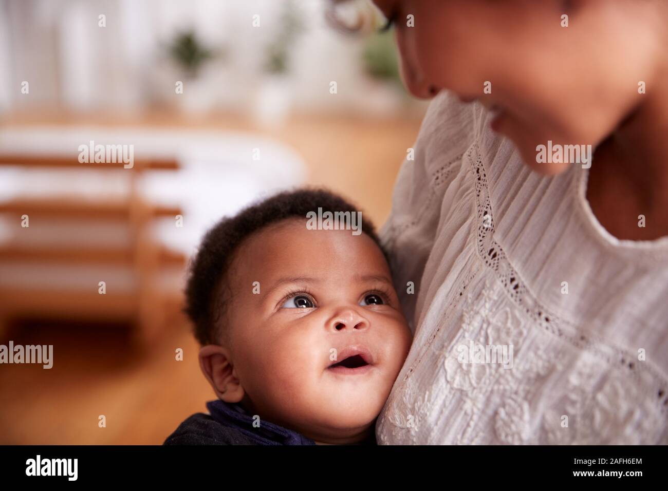 Loving Mother Holding Newborn Baby At Home In Loft Apartment Stock Photo