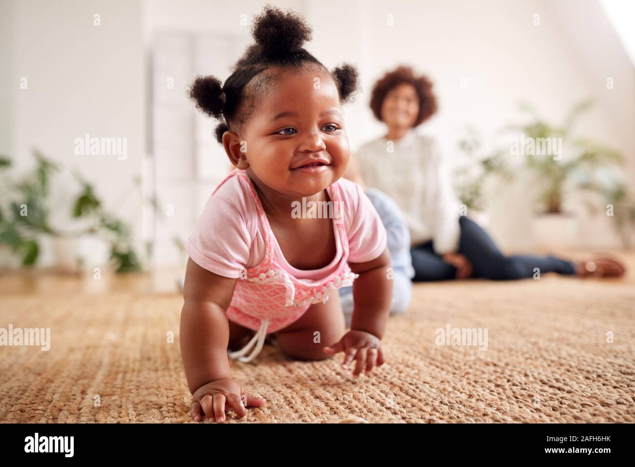 Two Mothers Meeting For Play Date With Babies At Home In Loft Apartment Stock Photo