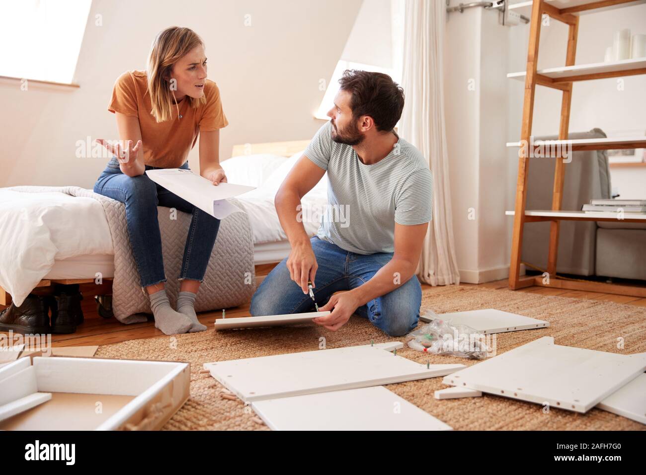 Couple Having Argument Whilst Putting Together Self Assembly Furniture Stock Photo