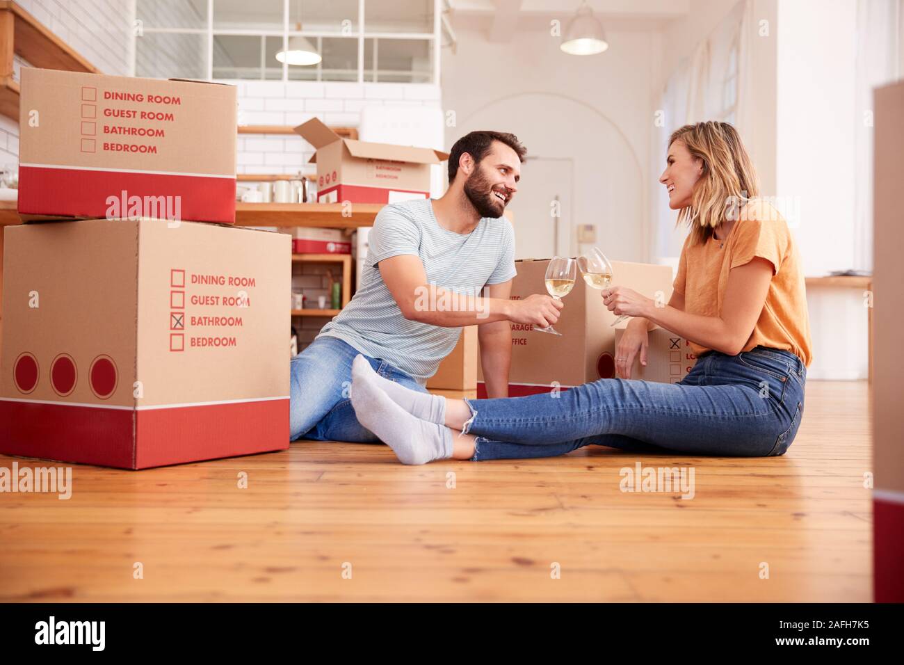 Couple Celebrating Moving Into New Home Drinking Champagne Stock Photo