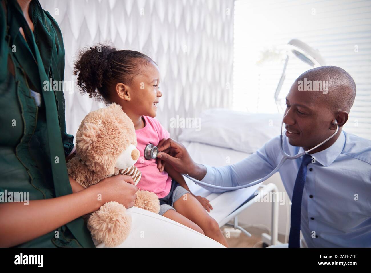 Mother Taking Daughter For Medical Exam In Doctors Office Stock Photo