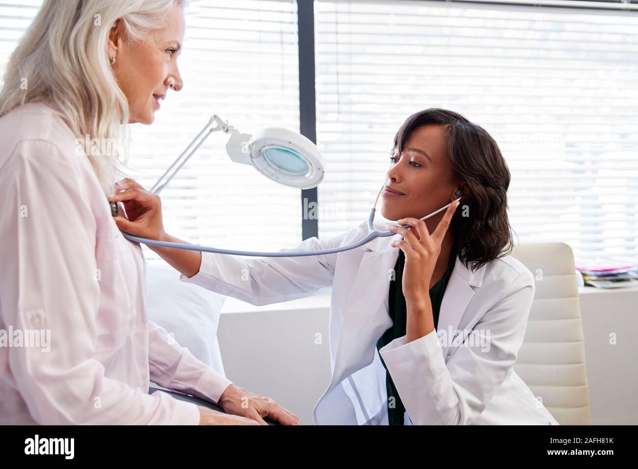 Woman Patient Having Medical Exam With Female Doctor In Office Stock Photo