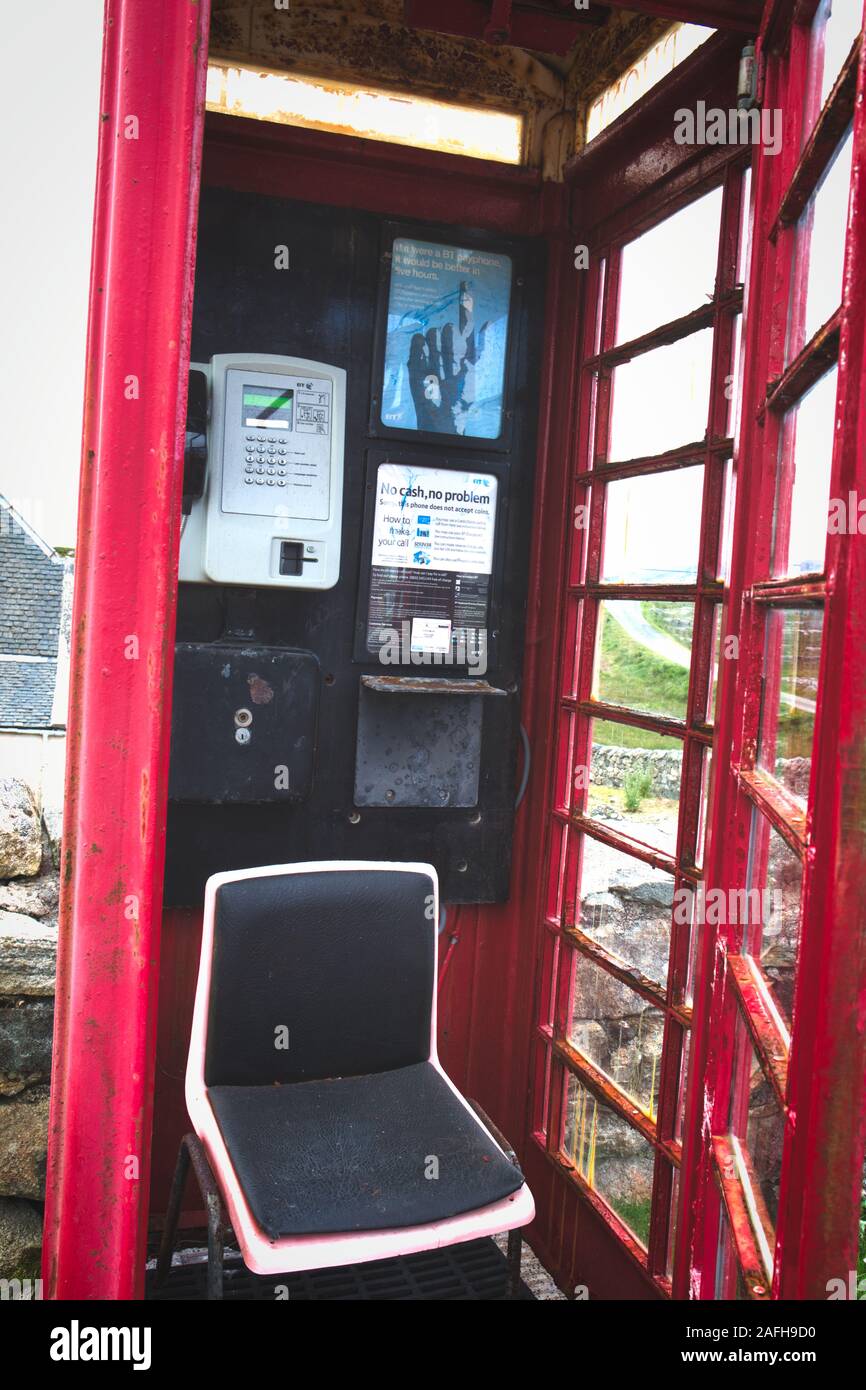 Chair in remote traditional red telephone box on the Isle of Harris, Outer Hebrides, Scotland Stock Photo