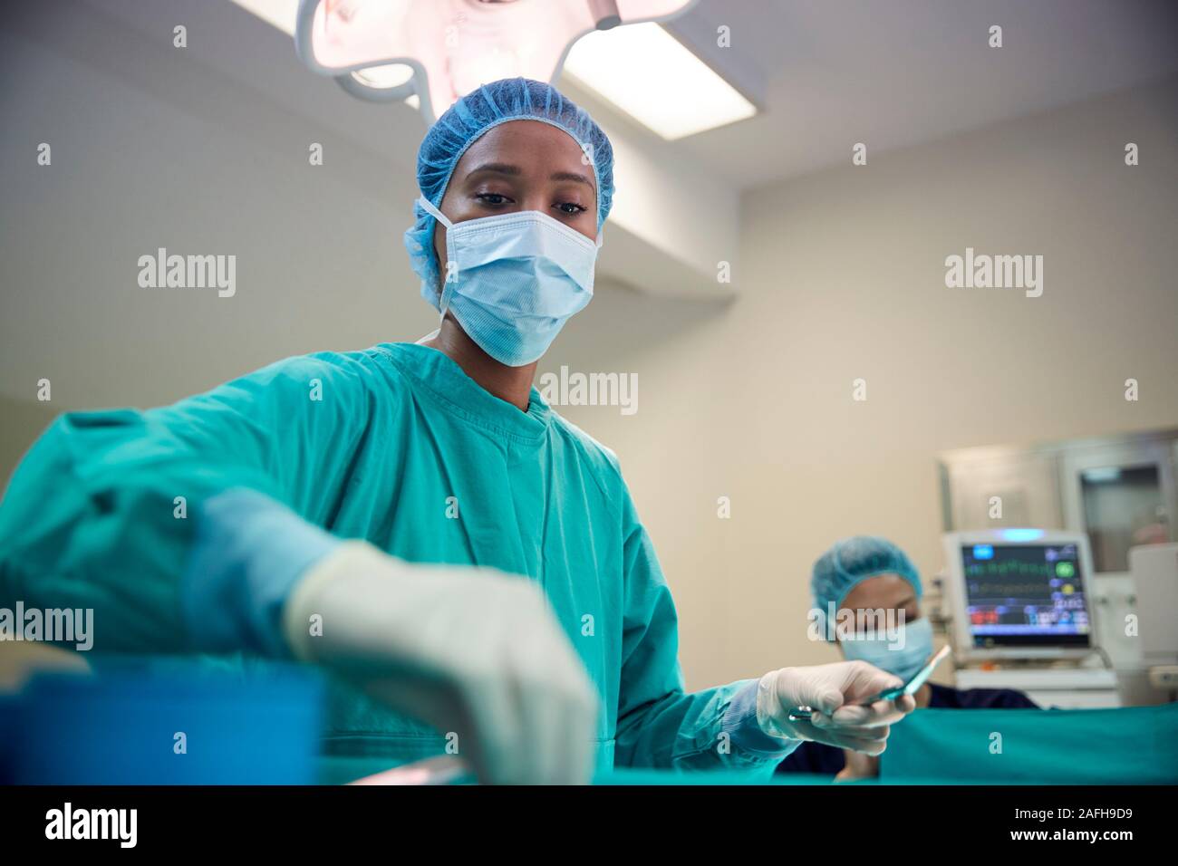 Female Surgical Team Working On Patient In Hospital Operating Theatre Stock Photo
