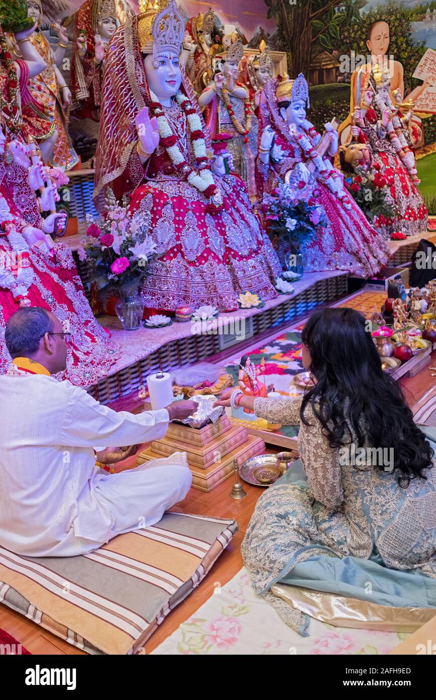 A Hindu woman with long hair celebrates her birthday by assisting with the morning service. At a temple in South Richmond Hill, Queens, New York City. Stock Photo