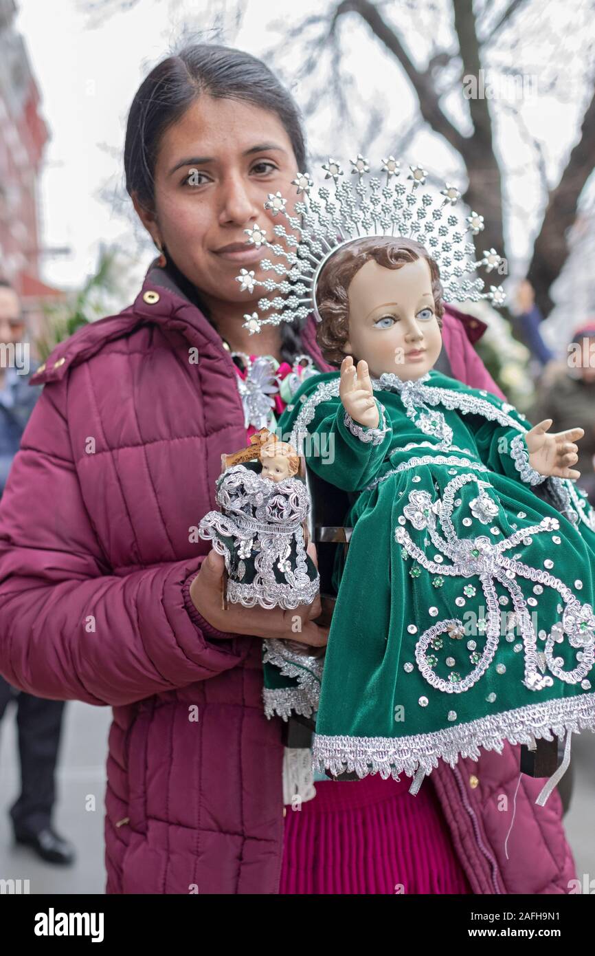 An Ecuadorian American Catholic woman in a mid December march with a statue of Baby Jesus to celebrate the birth of Christ. In Corona, Queens, NYC. Stock Photo