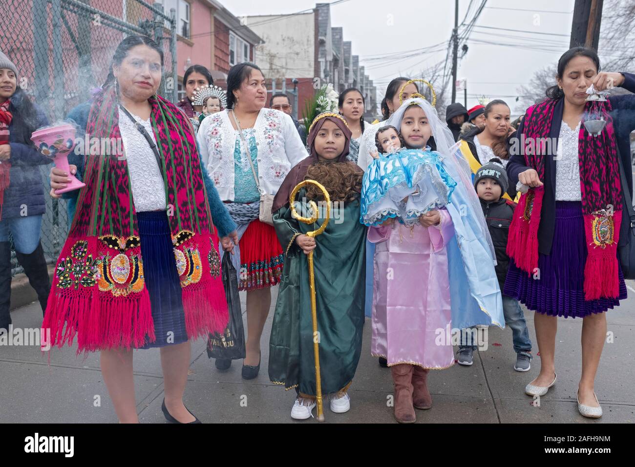 Ecuadorian Americans Catholics march in mid December to celebrate the birth of Jesus. The children are dressed as Joseph & Mary. Corona, Queens, NYC. Stock Photo