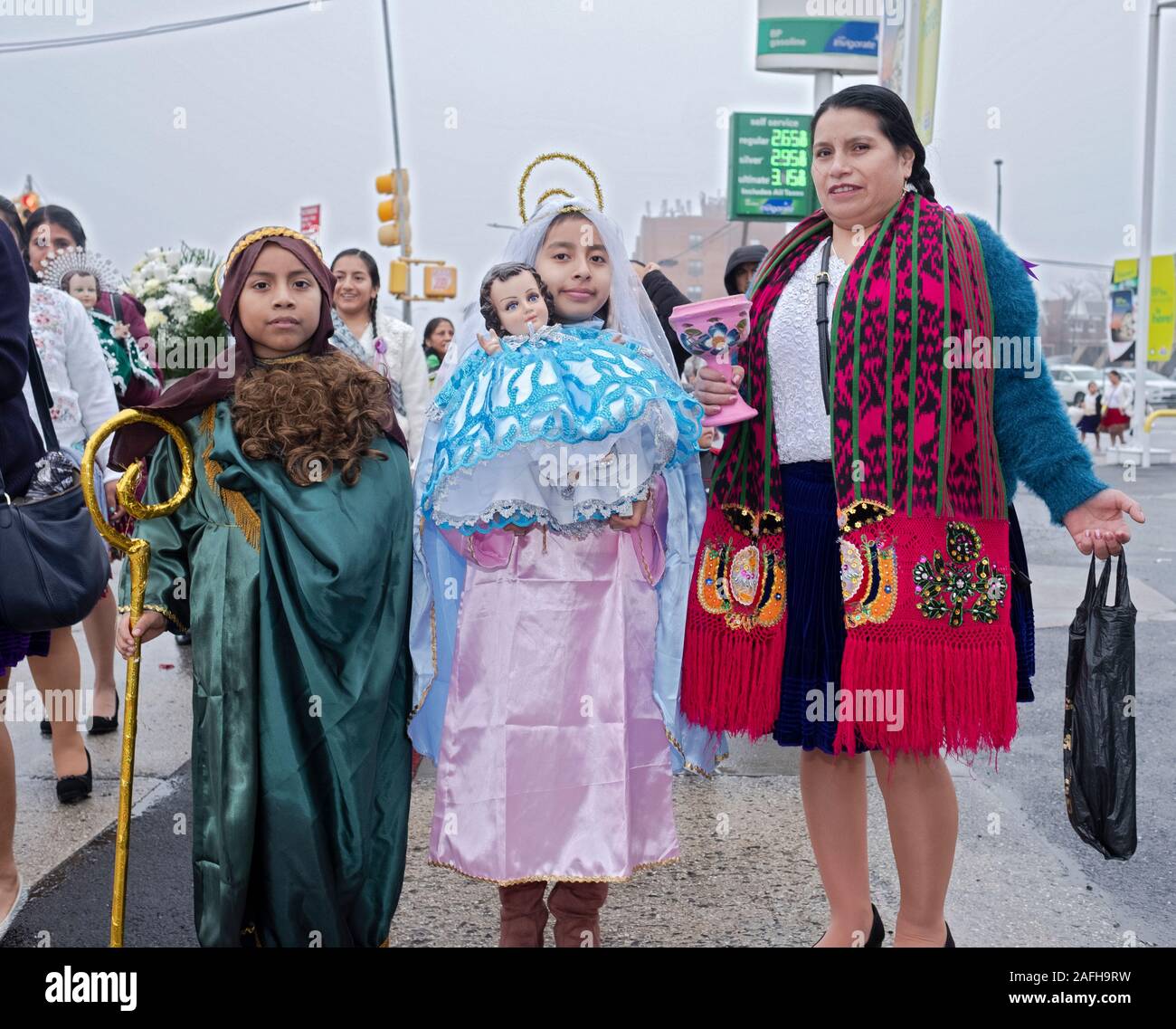 Ecuadorian American Catholics march in mid December to celebrate the birth of Jesus. The children are dressed as Joseph & Mary. Corona, Queens, NYC. Stock Photo