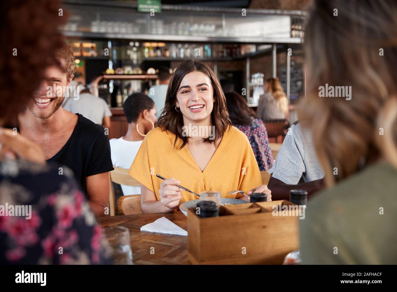 Group of friends sitting at bar hi-res stock photography and images - Alamy