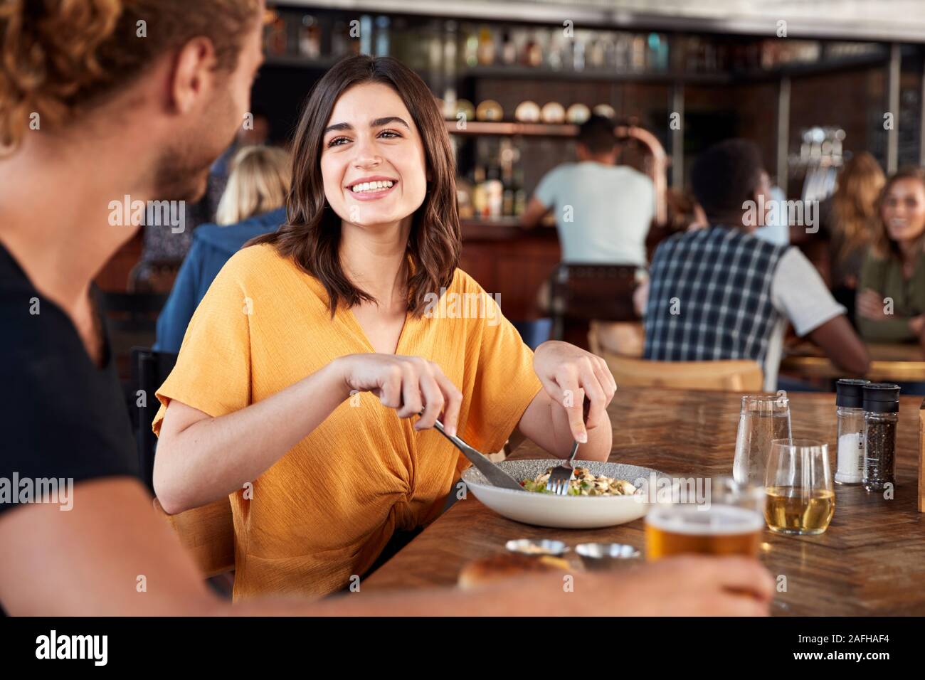 Couple On Date Meeting For Drinks And Food In Restaurant Stock Photo