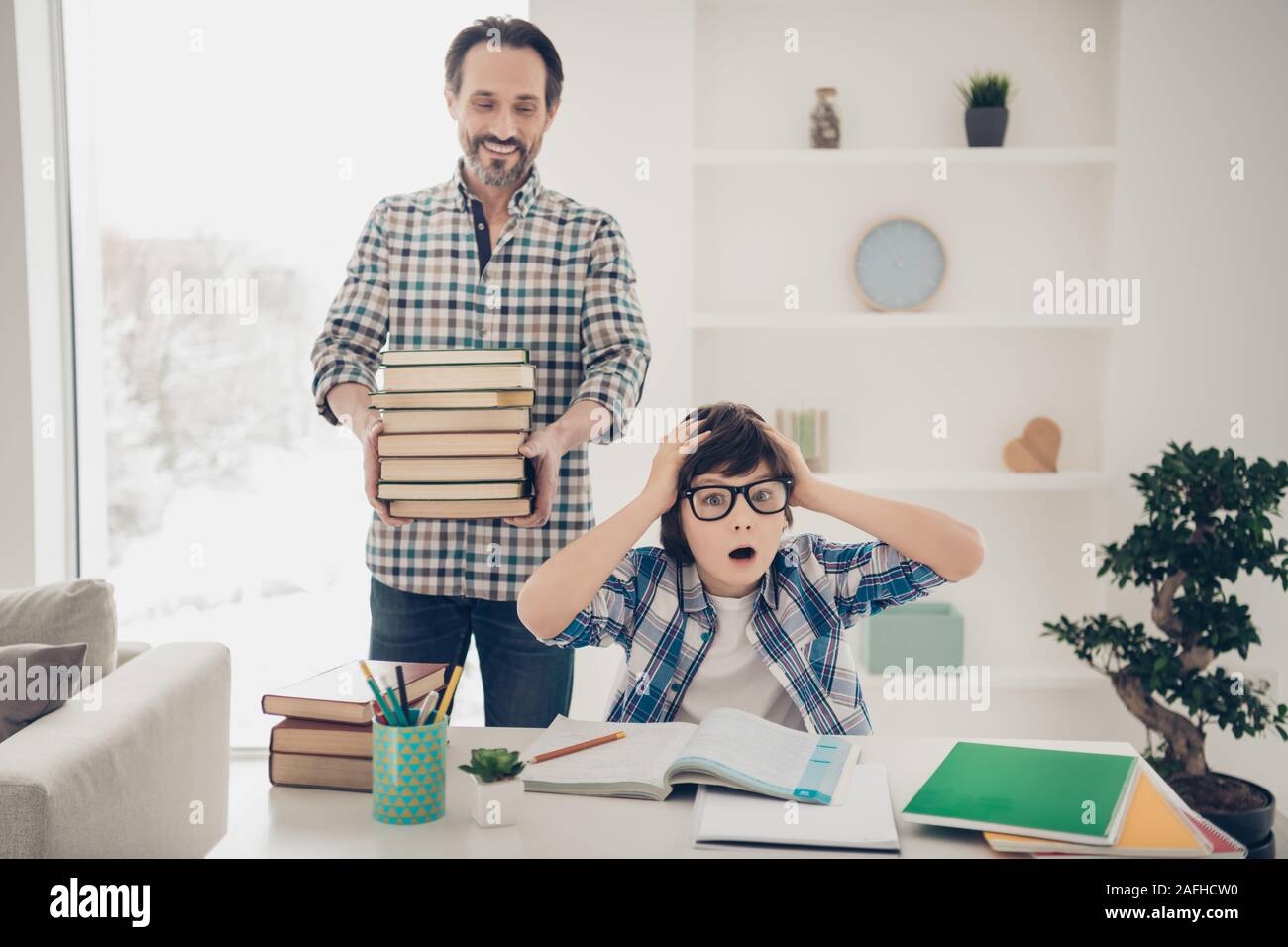I want to have weekend concept. Photo of sad upset surprised crazy little guy touching head hate studying sitting at table and his dad prepared him Stock Photo