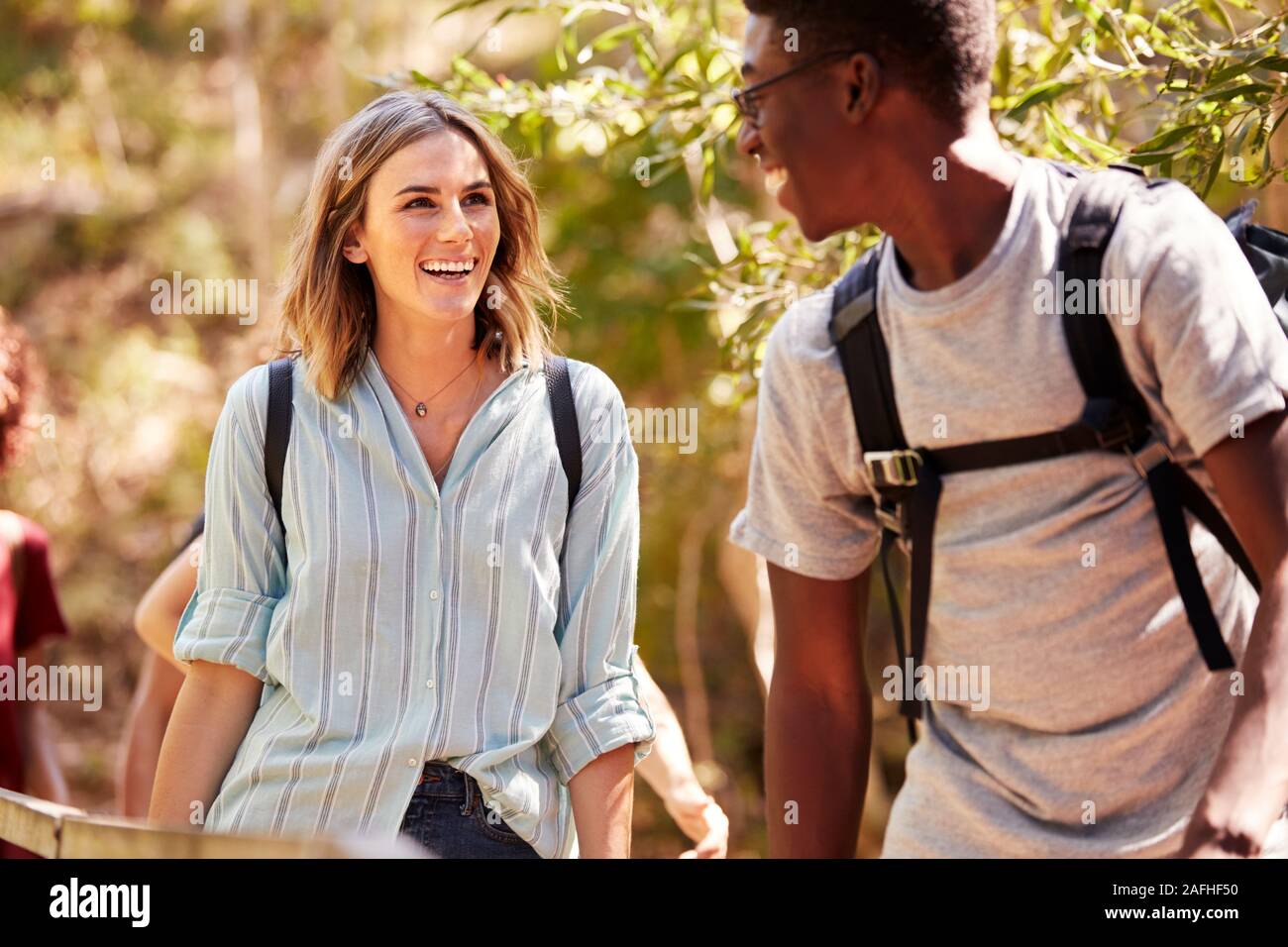 Happy mixed race millennial couple hiking in a forest together, waist up, close up Stock Photo