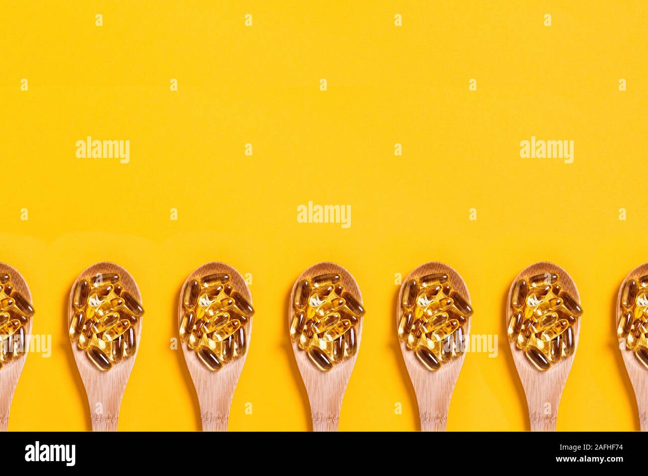 Medical background. Fish oil in a wooden spoon. Central composition. Stock Photo