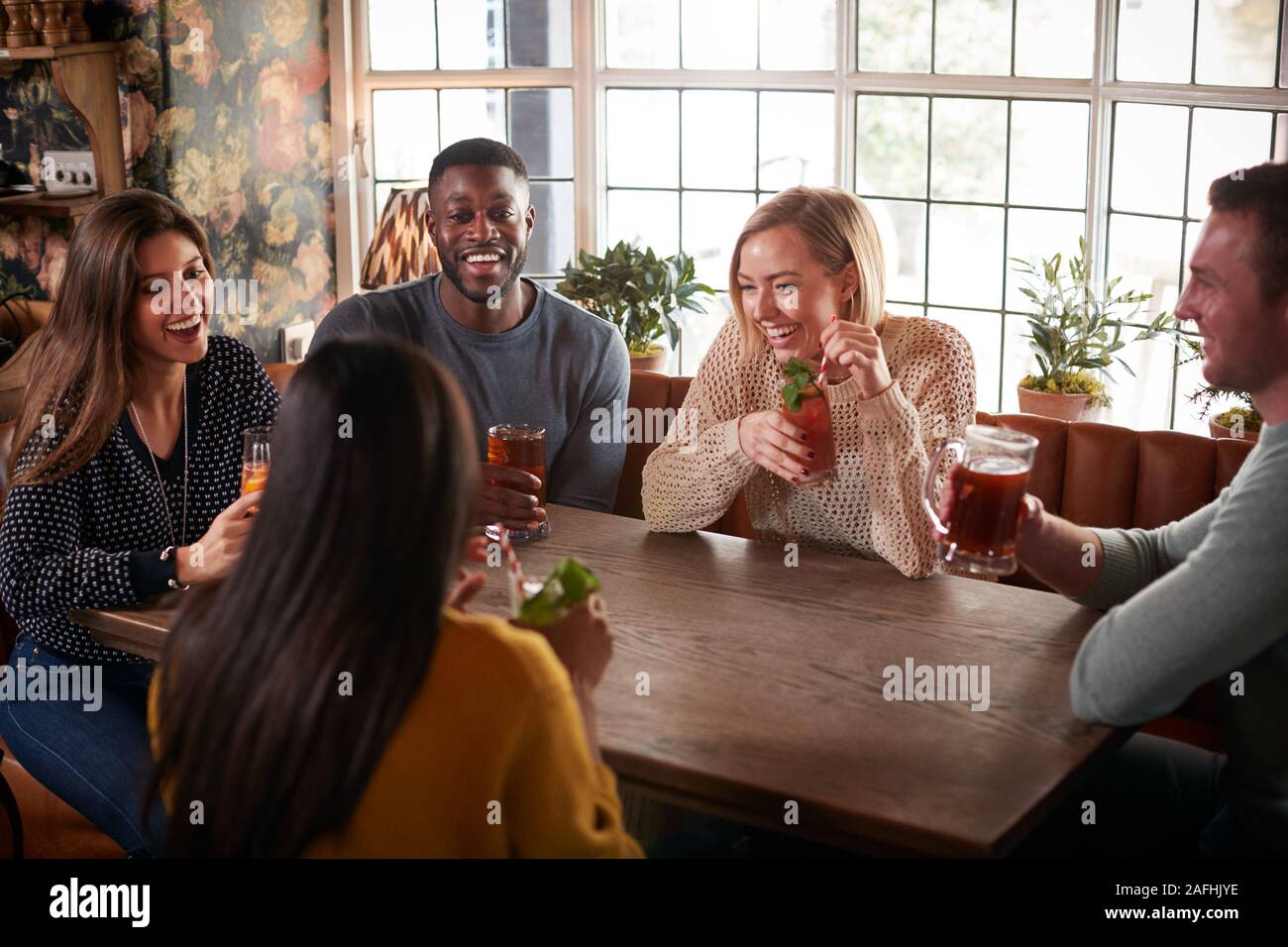 Group Of Friends Meeting For Lunchtime Drinks In Traditional English Pub Stock Photo