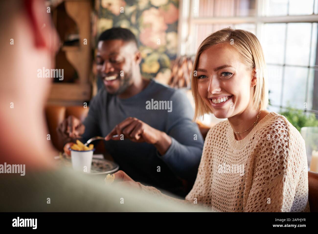 Group Of Friends Meeting For Meal In Traditional English Pub Stock Photo