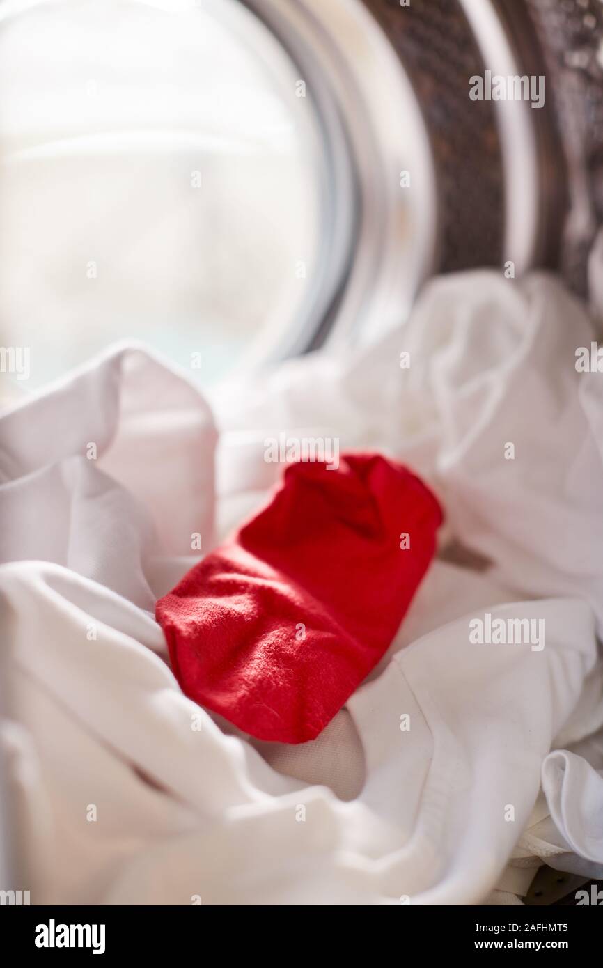 View Looking Out From Inside Washing Machine With Red Sock Mixed With White Laundry Stock Photo