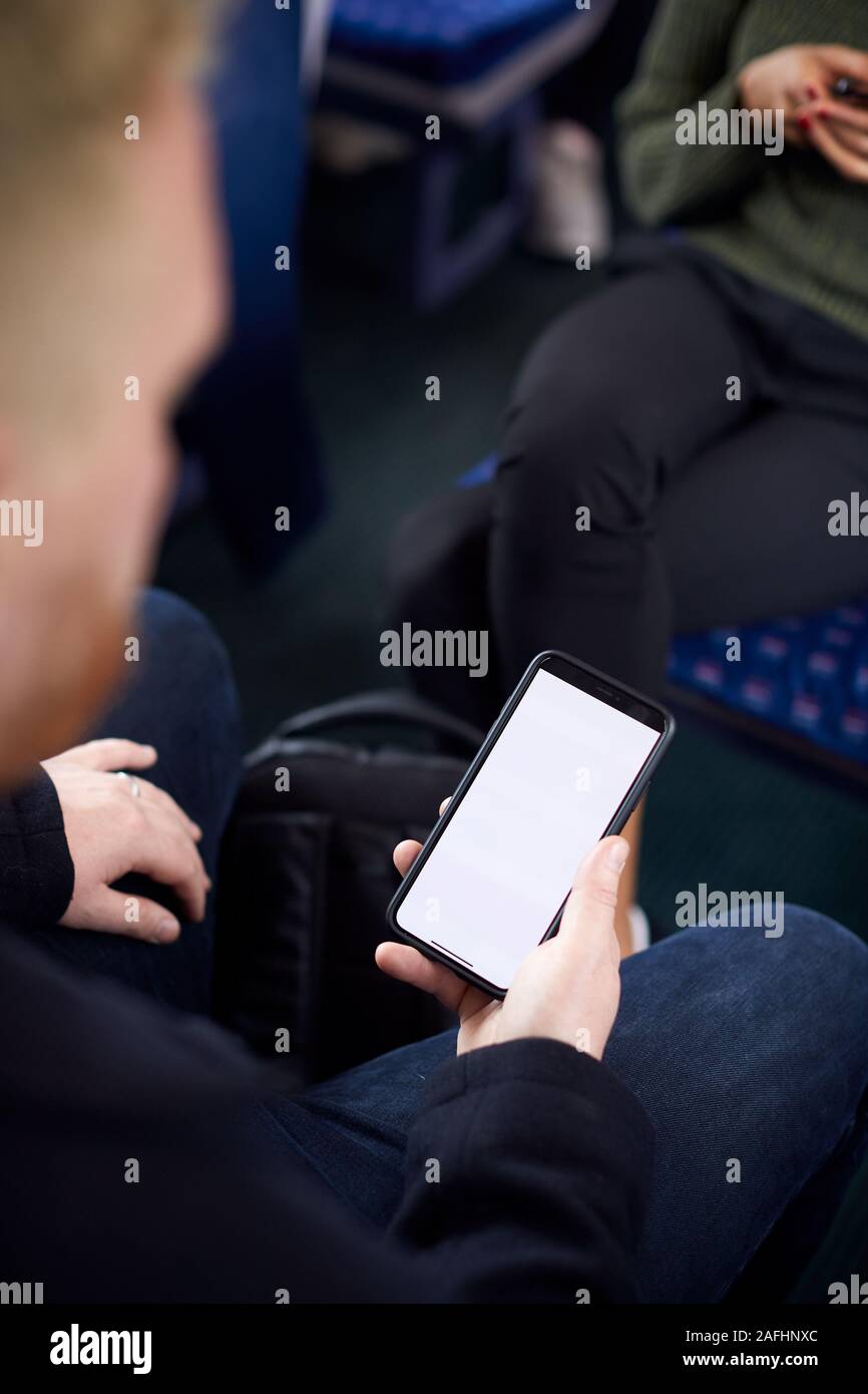 Close Up Of Male Passenger Sitting In Train With Digital Ticket On Mobile Phone Stock Photo
