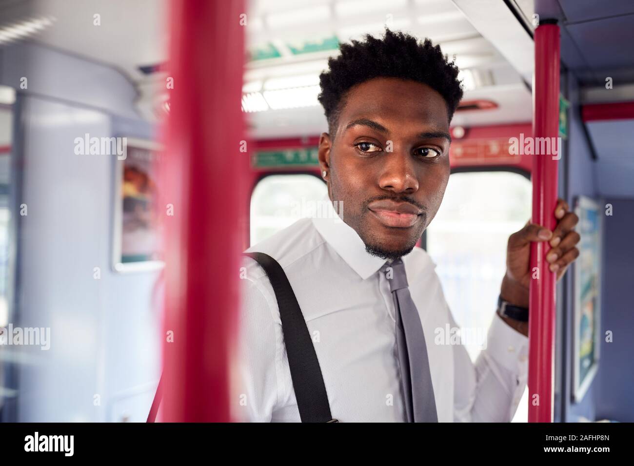 Businessman Standing In Train Commuting To Work Stock Photo