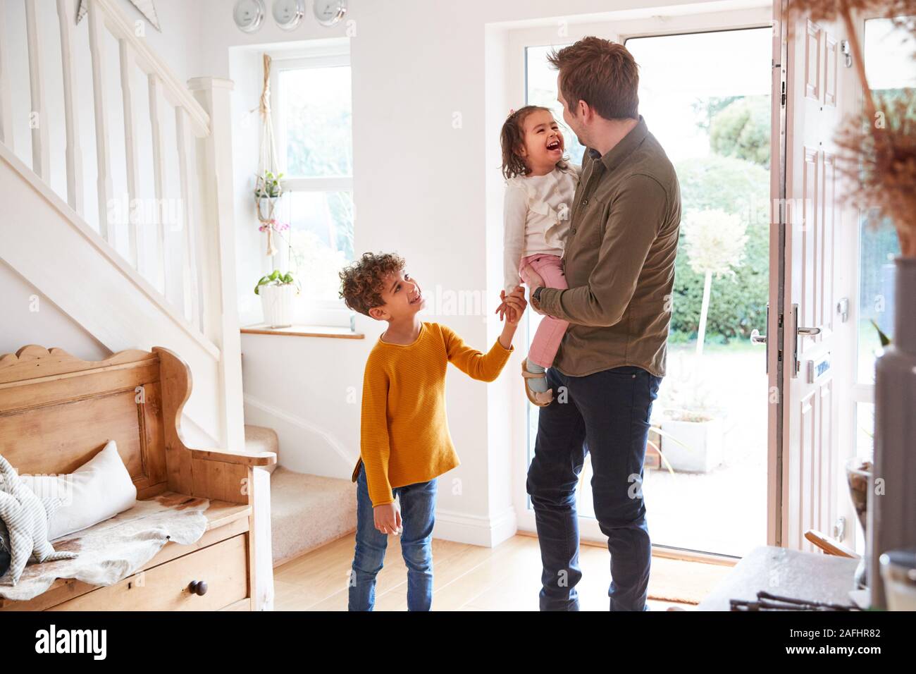 Single Father Returning Home After Trip Out With Excited Children Running Ahead Stock Photo