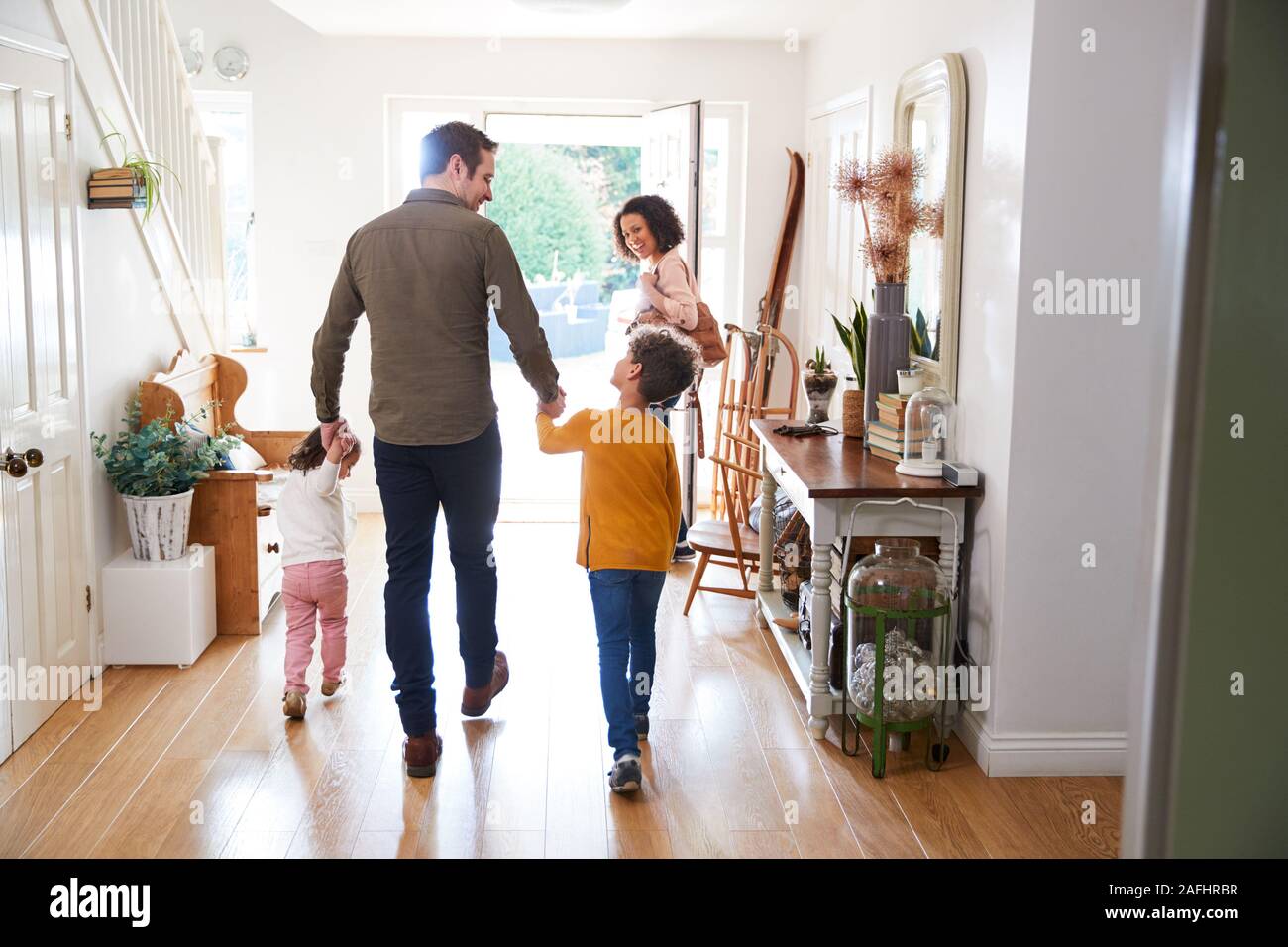 Rear View Of Family Leaving Home On Trip Out With Excited Children Stock Photo