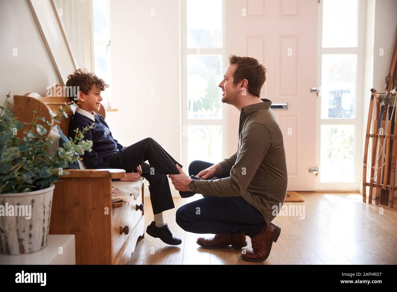 Single Father At Home Getting Son Wearing Uniform Ready For First Day Of School Stock Photo